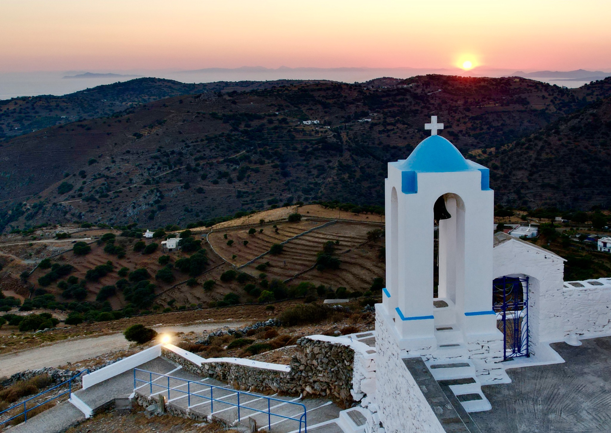 Coucher de soleil sur une église blanche et bleue à Kea